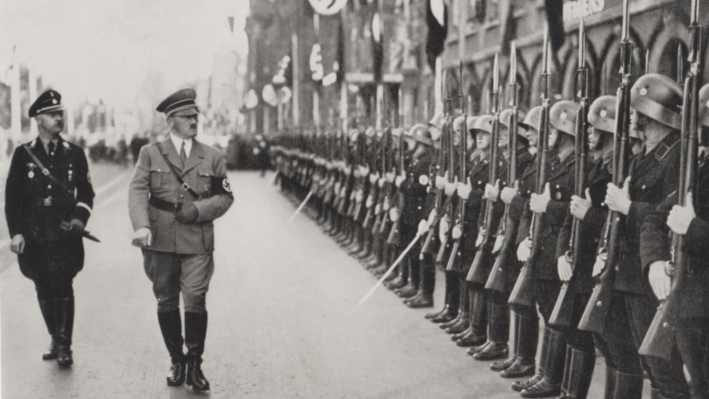 "Der Zweite Weltkrieg: Die Welt am Abgrund": Schwarz-Weiß-Aufnahme: Adolf Hitler schreitet, gefolgt von Heinrich Himmler, an einer Reihe angetretener Soldaten vorbei.