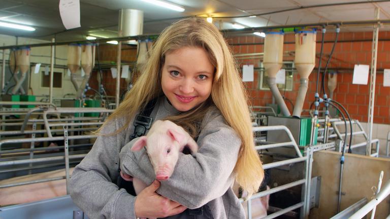 "Die Schnitzel-Industrie - Das Geschäft mit Deutschlands Schweinen": Hannah Thalhammer hält ein Ferkel auf dem Arm und lacht in die Kamera.