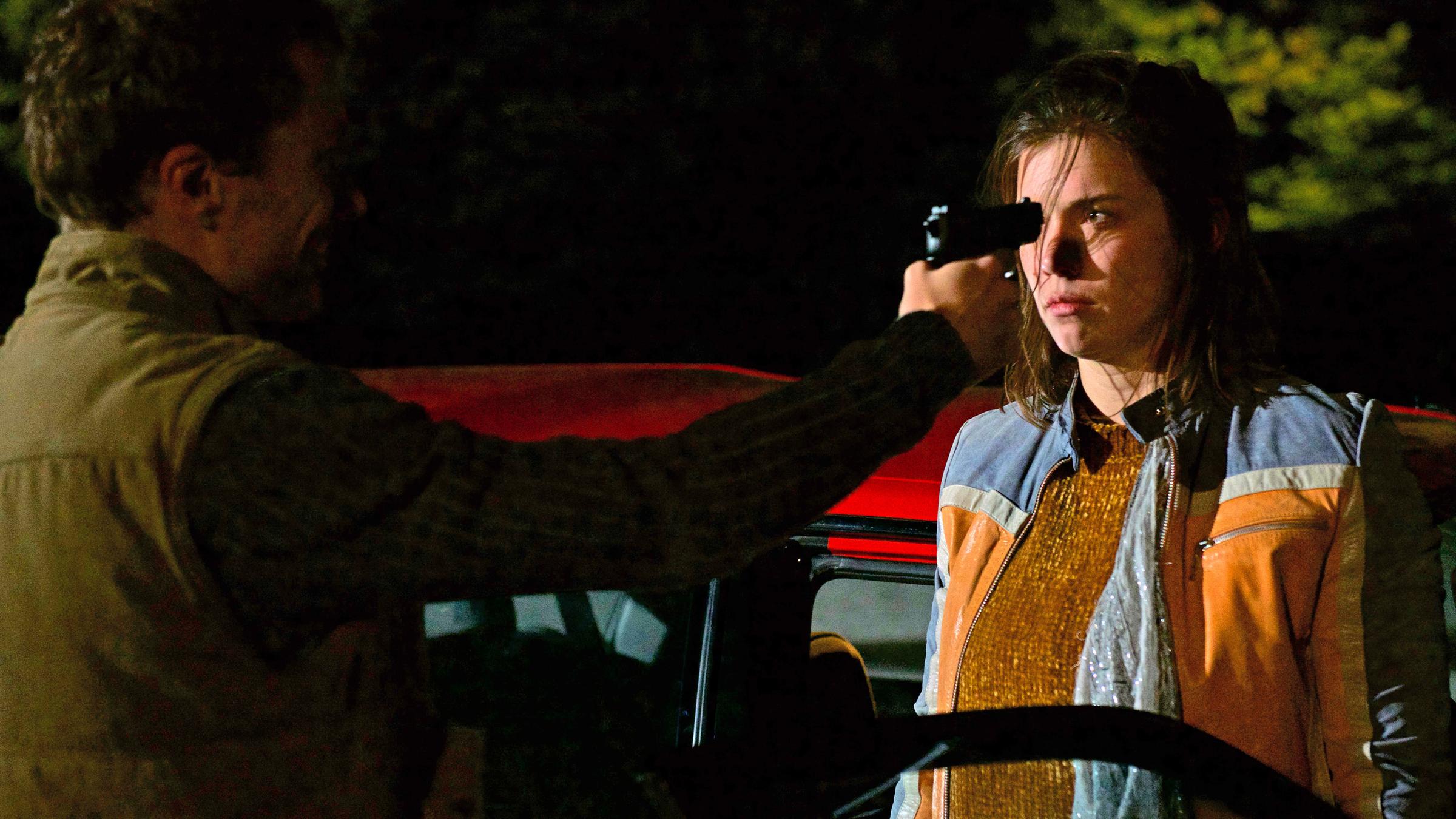 "Aktenzeichen XY... gelöst": Es ist dunkel, ein junges Mädchen steigt aus dem Auto aus. Vor dem Mädchen steht ein Mann, er hält eine Pistole dicht vor das Gesicht der jungen Frau.