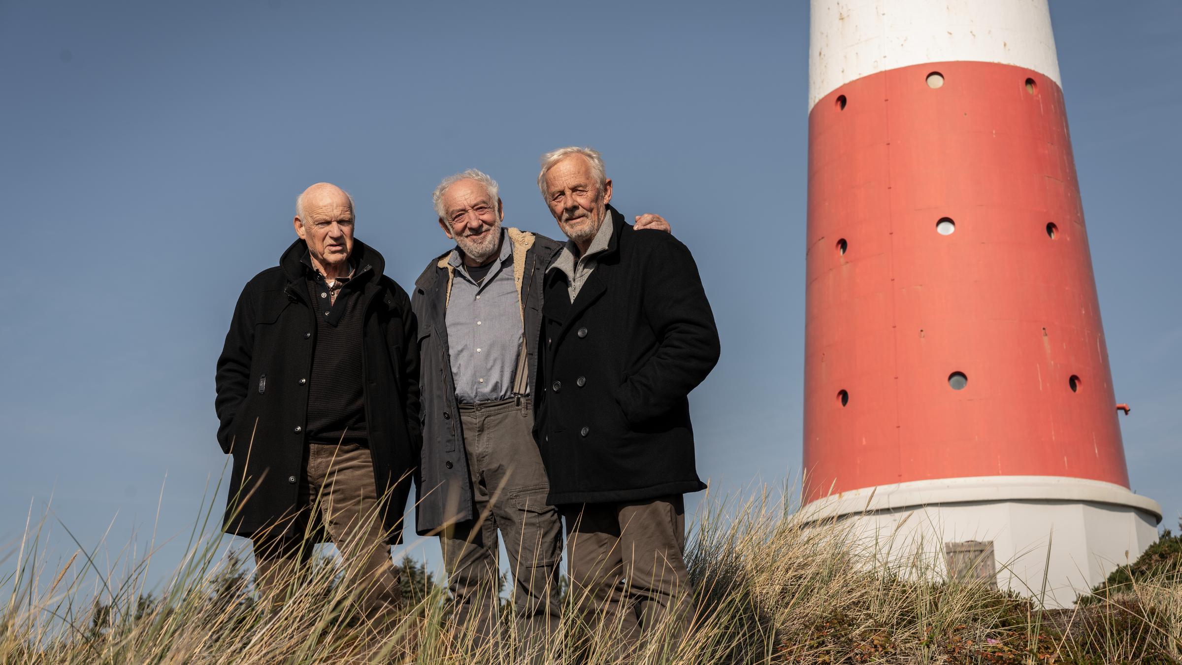 „Nord Nord Mord – Sievers und die Tote im Strandkorb“: Ingo Osborn (Dietrich Hollinderbäumer), Olaf Bolt (Dieter Hallervorden) und Piet Pinter (Rolf Becker) stehen in den Dünen an einem Leuchtturm.