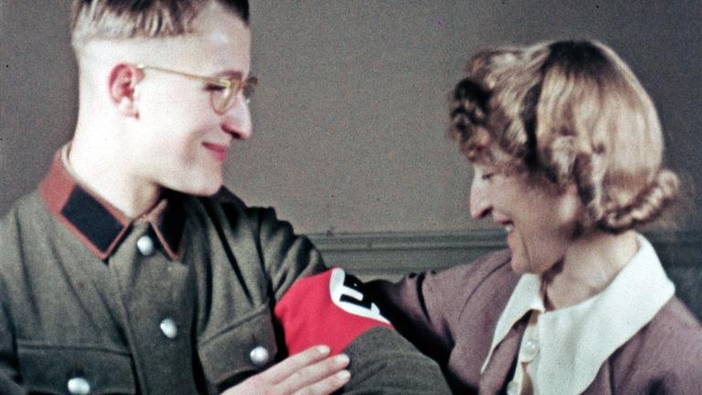 "Wir im Krieg – Privatfilme aus der NS-Zeit": Sohn von Hans Burscher in NS-Uniform. Daneben seine Mutter, die seine Hakenkreuzbinde bewundert.