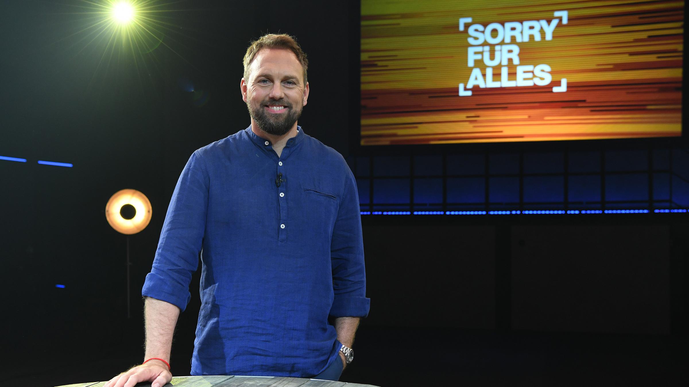"Sorry für alles": Moderator Steven Gätjen steht im Studio und lacht in die Kamera.