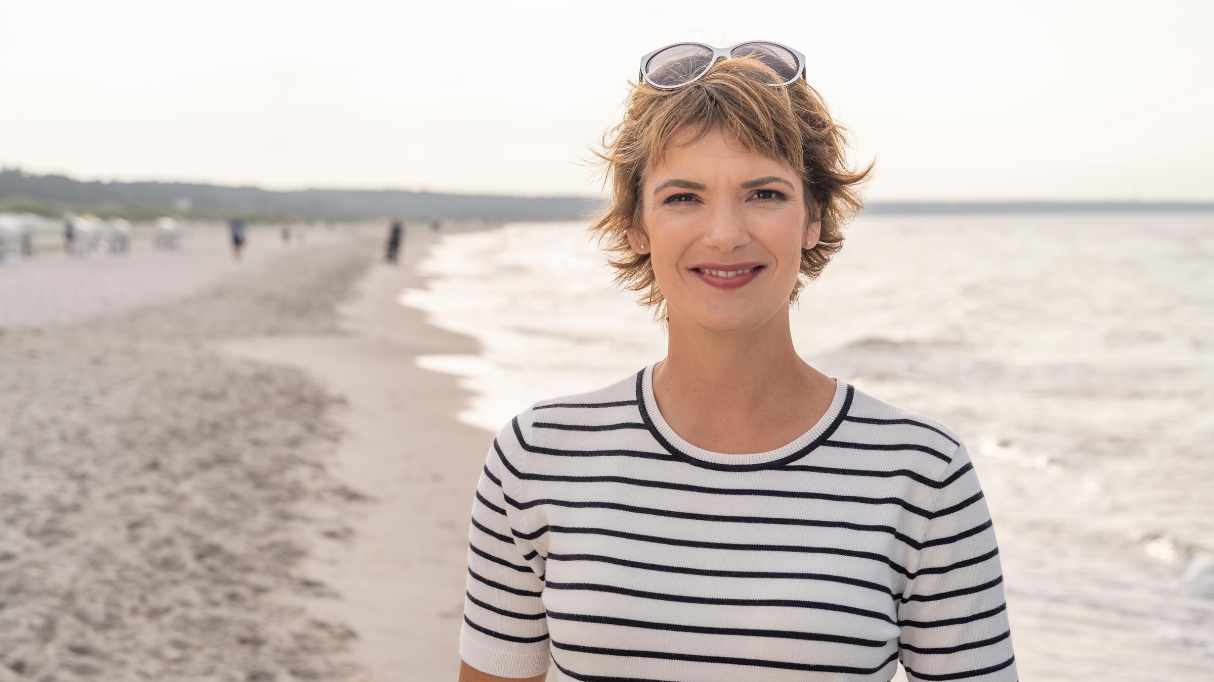 "Terra Xpress: Erlebnisreise - Mein Strand gehört mir und der Traum vom Inselglück": Moderatorin Lena Ganschow steht am Strand. Im Hintergrund der Strand und das Meer.