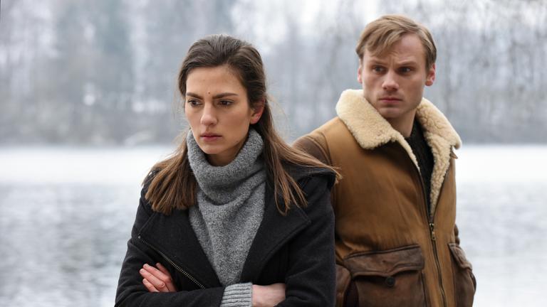 "Winterherz - Tod in einer kalten Nacht": In der  Winterlandschaft sieht Mike (Anton Spieker) der  ihm abgewandten Sylvie (Laura de Boer ) nach und erwartet eine Antwort.