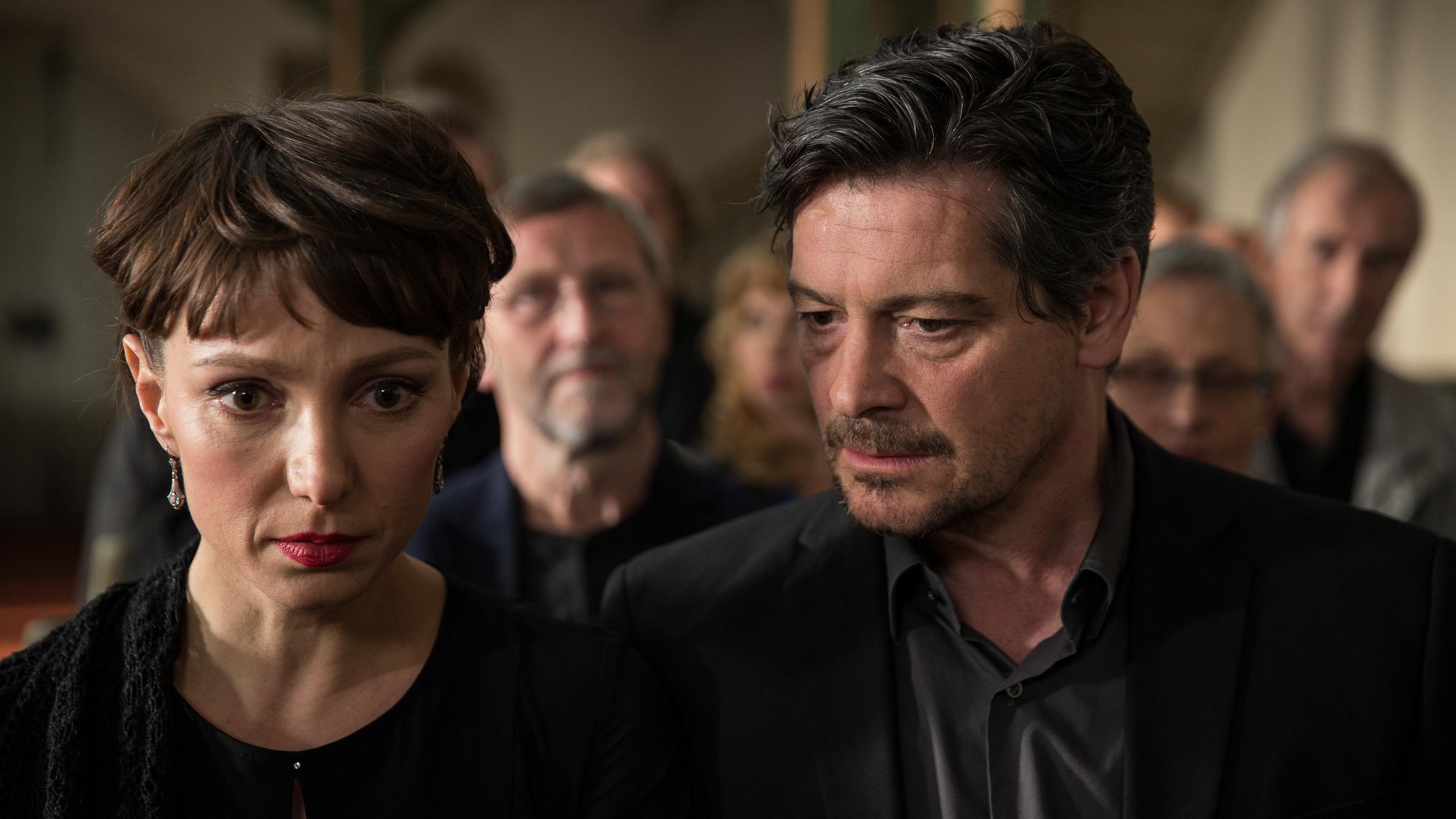 "Unterm Birnbaum": Ursel (Julia Koschitz, l.)und Abel Hradschek (Fritz Karl, r.) schwarz gekleidet in der Kirche. Er blickt seitlich zu ihr.