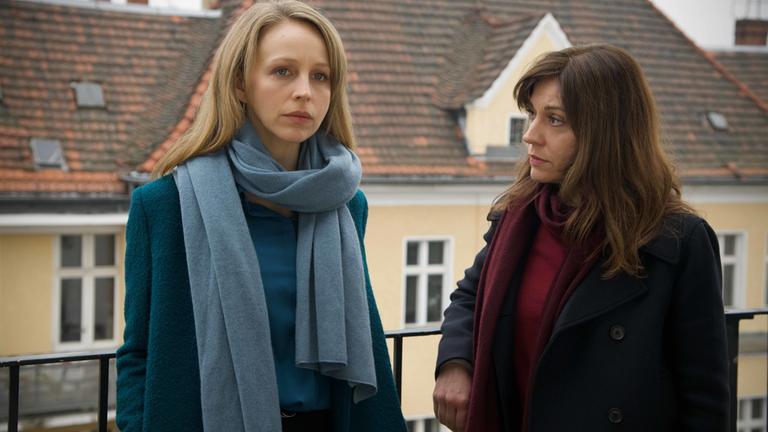  "Getrieben": Kara Bischoff (Petra Schmidt-Schaller) und Sibylle Deininger (Ulrike C. Tscharre) lehnen sich an ein Terrassengeländer. Beide sehen nachdenklich aus.