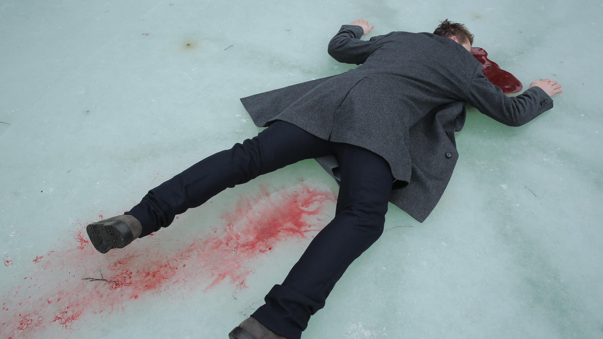  "Landkrimi - Der Tote am Teich": Ein Toter liegt bäuchlings auf einem zugefrorenen Teich in seiner Blutpfütze. Es ist eine Blutspur zu sehen.