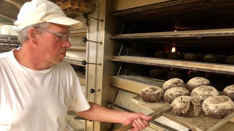 "ZDF.reportage Reicht die Rente? - Was vom Arbeitsleben übrig bleibt": Die Bäckerei Hinkel in Düsseldorf. Günther D. schiebt Brote in einen Ofen.