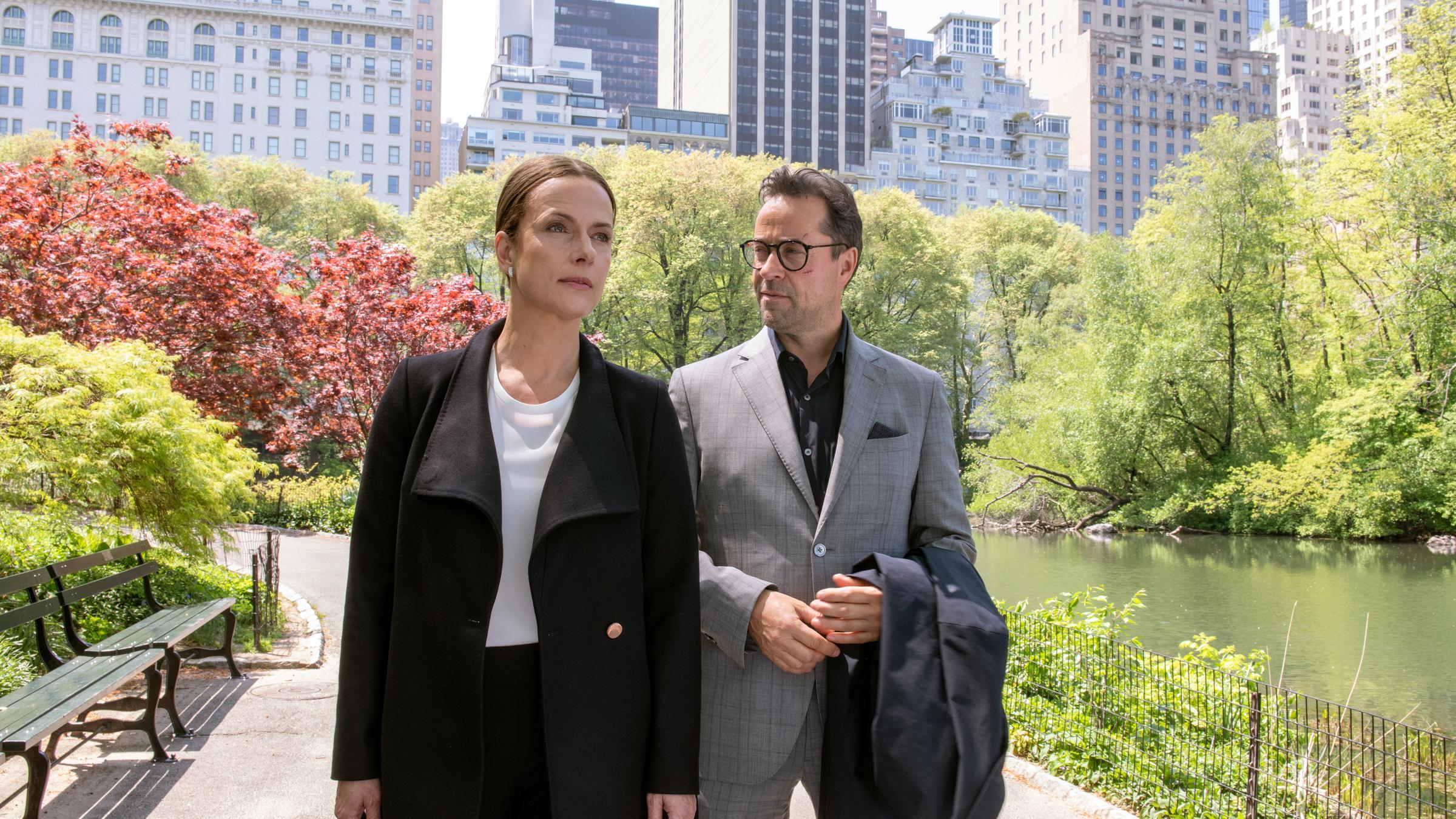 "Totengebet": Rebecca (Claudia Michelsen) und Joachim Vernau (Jan Josef Liefers) laufen nebeneinander durch einen Park. Im Hintergrund sieht man Hochhäuser.