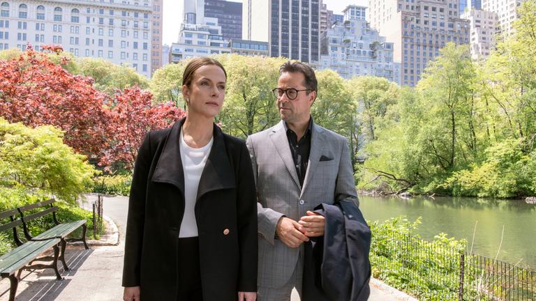 "Totengebet": Rebecca (Claudia Michelsen) und Joachim Vernau (Jan Josef Liefers) laufen nebeneinander durch einen Park. Im Hintergrund sieht man Hochhäuser.
