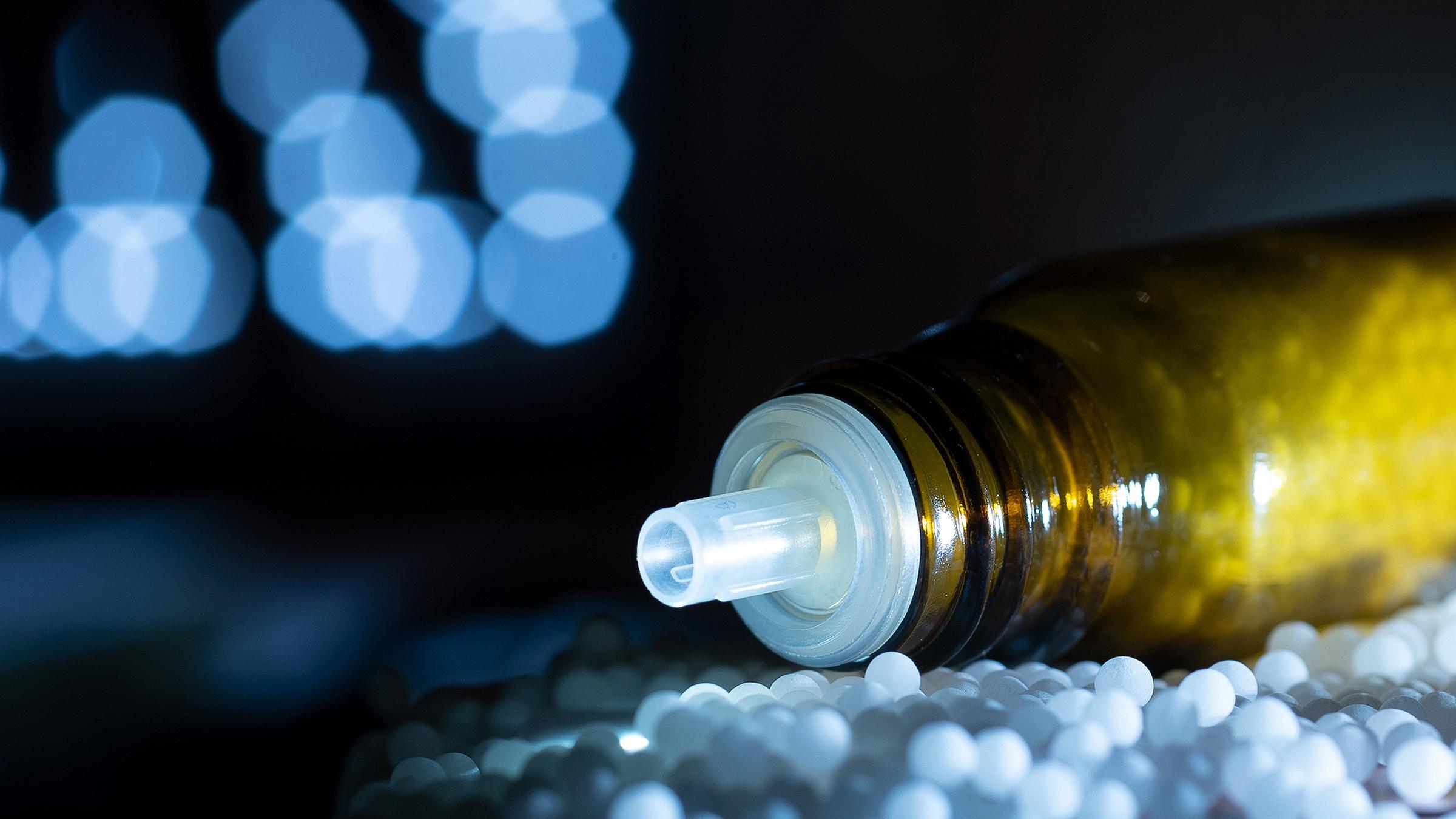 "ZDFzoom: Globuli und guter Glaube - Homöopathie auf dem Prüfstand": Auf einem Tisch liegt ein Fläschchen mit Globuli-Kugeln gefüllt.