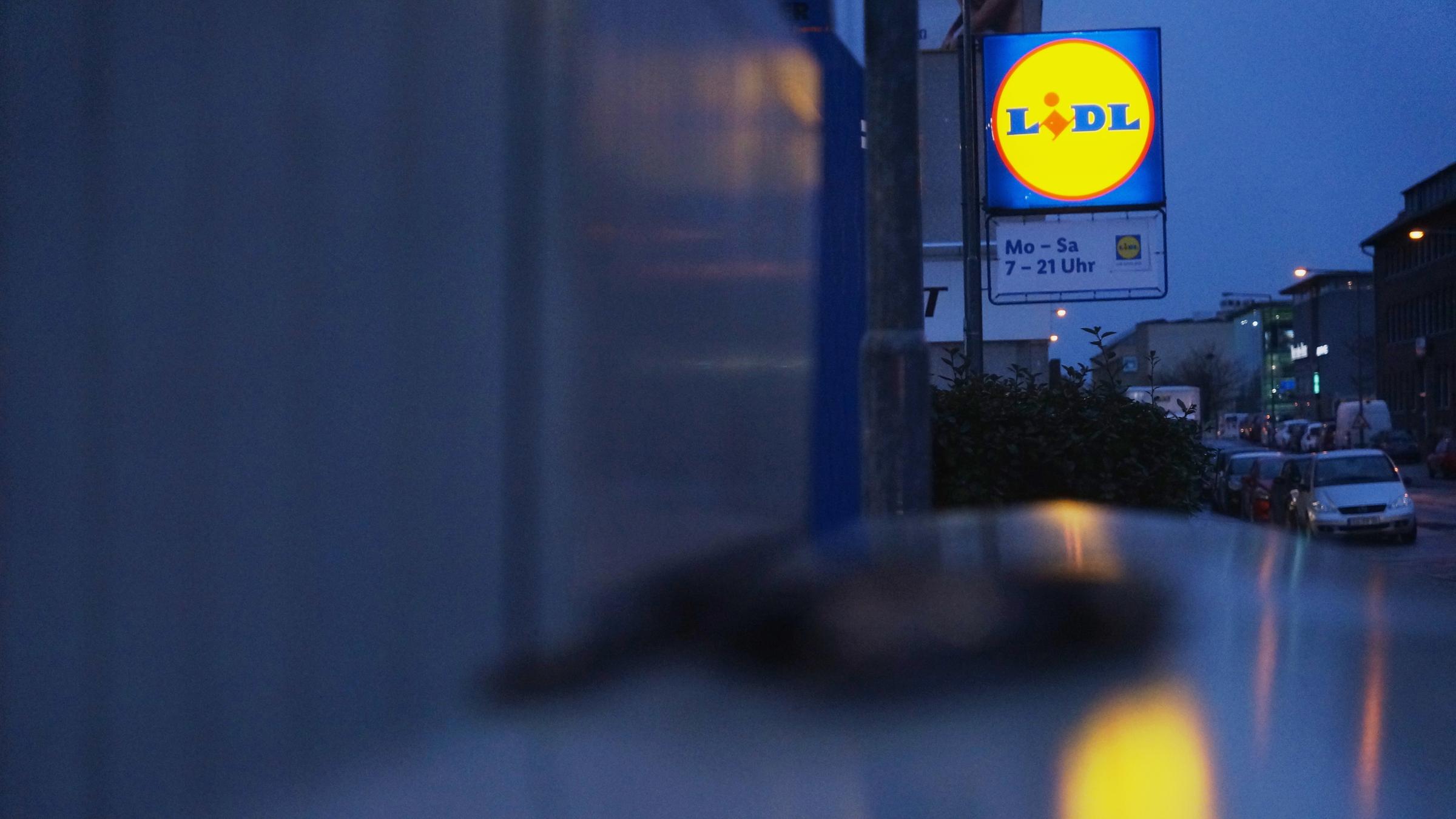 "ZDFzoom: Hauptsache billig? - Das System Discounter": Das Lidl-Symbol leuchtet am Ende einer regennassen Straße.