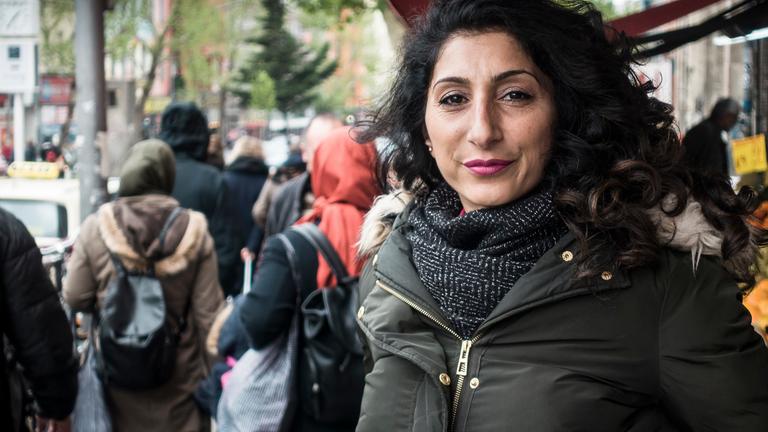 "37°: Im Schatten der Clans - Eine Frage der Ehre": Die 44-jährige türkischstämmige Sozialarbeiterin Songül Ç. steht auf einer belebten Geschäftsstraße in Berlin-Neukölln und blickt selbstbewusst in die Kamera. In der linken Bildhälfte von hinten zu sehen: zwei Frauen mit Kopftüchern.