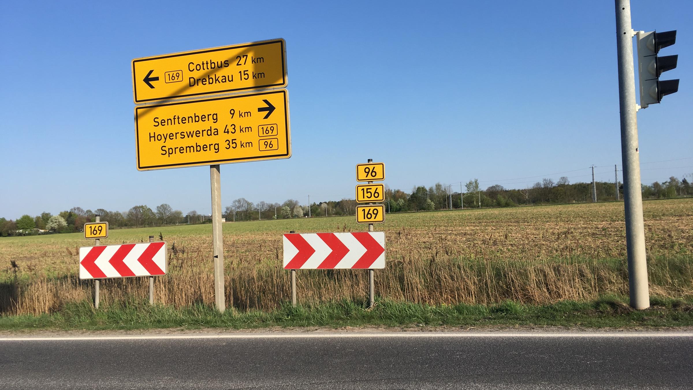 "ZDF.reportage: B96 - Roadtrip auf der Straße der Träume - Von der Oberlausitz bis nach Berlin": Blick auf ein Straßenschild auf der B96. Im Hintergrund ein abgemähtes Feld.
