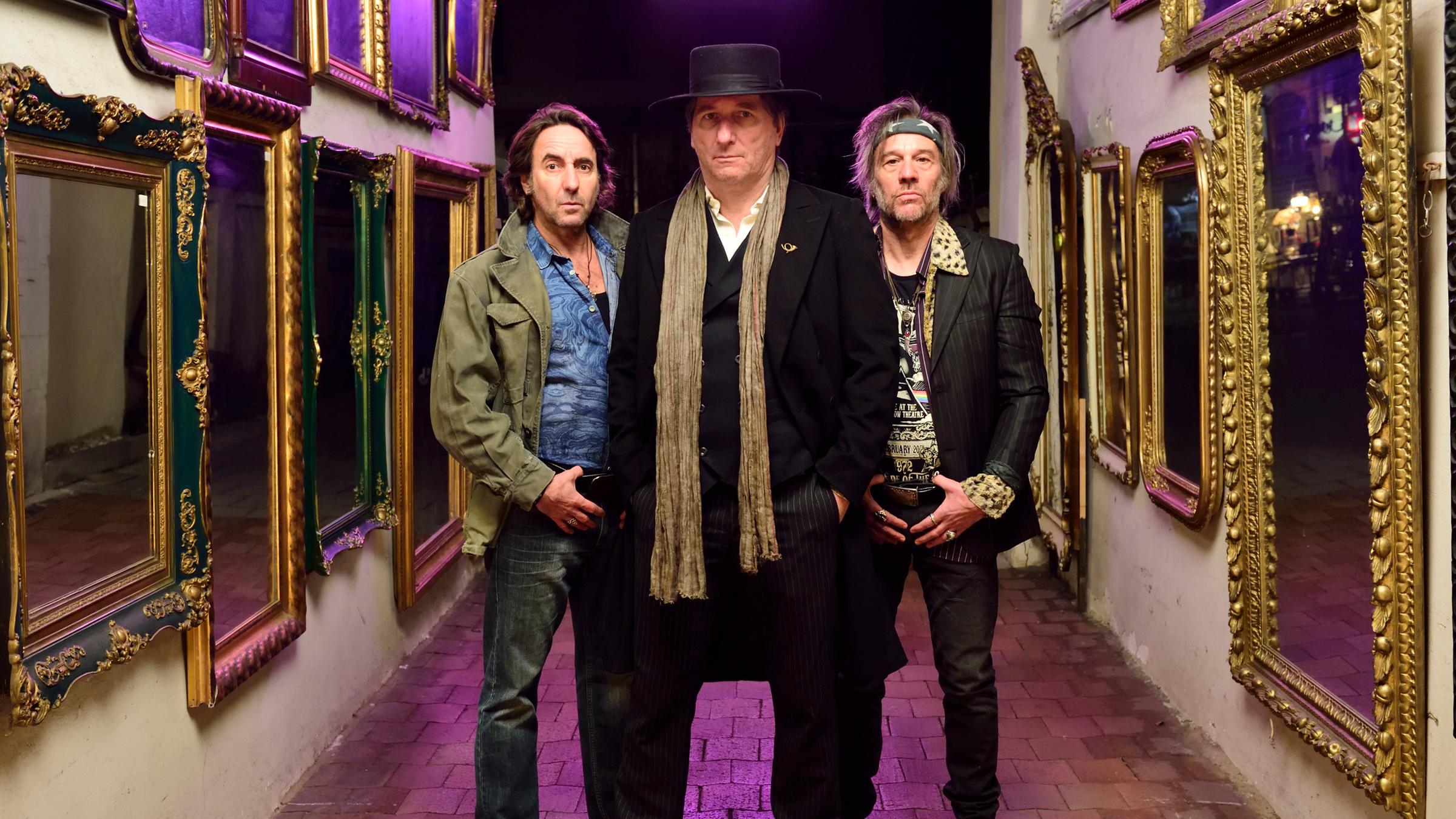 "München Mord - Leben und Sterben in Schwabing": Girgl Hofmann (Dieter Landuris), Türkenrudi (Michael Fitz) und Heinzi Murnauer (Johann Nikolussi) stehen in einer Einfahrt. An den Wänden hängen mehrere Spiegel.