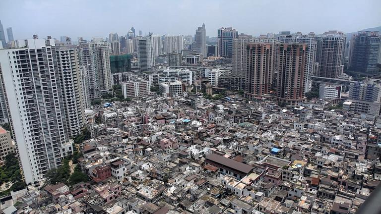"Stadt frisst Mensch - Chinas Megacities": Das städtische Dorf Yanzji in  Guangzhou. Im Hintergrund viele Hochhäuser.