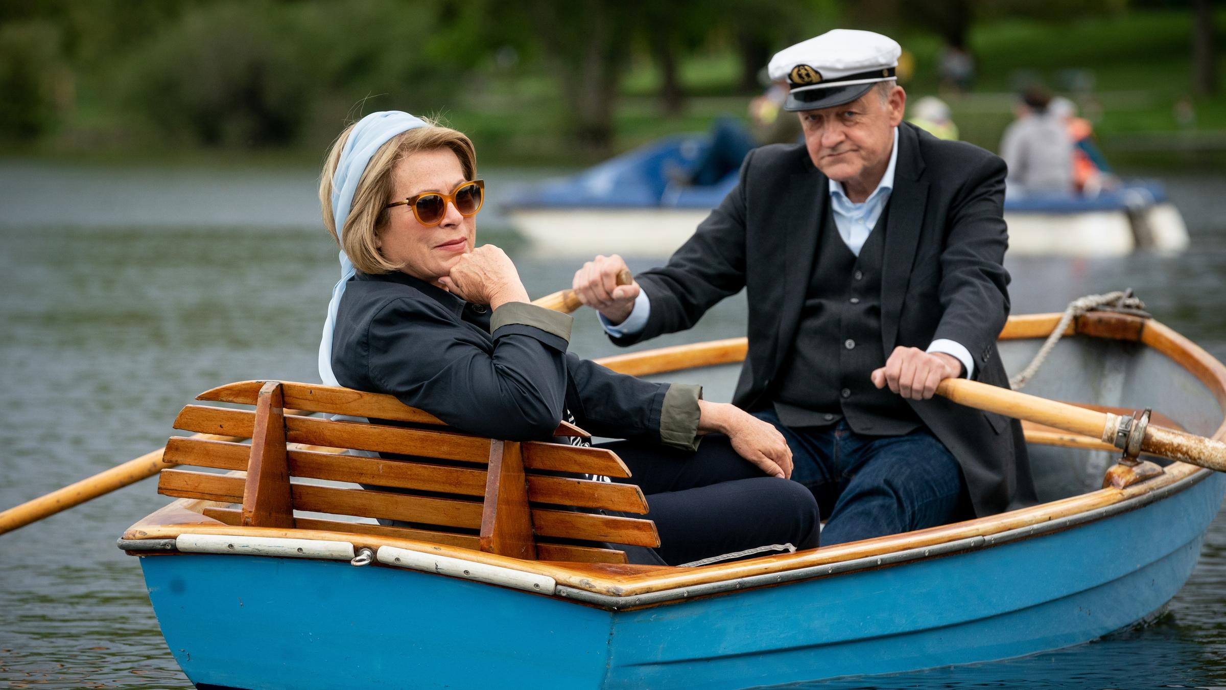 "Wilsberg - Schutzengel": Anna Springer (Rita Russek) sitzt in einem Holzboot auf dem Aasee und überlässt Georg Wilsberg (Leonard Lansink) das Rudern.
