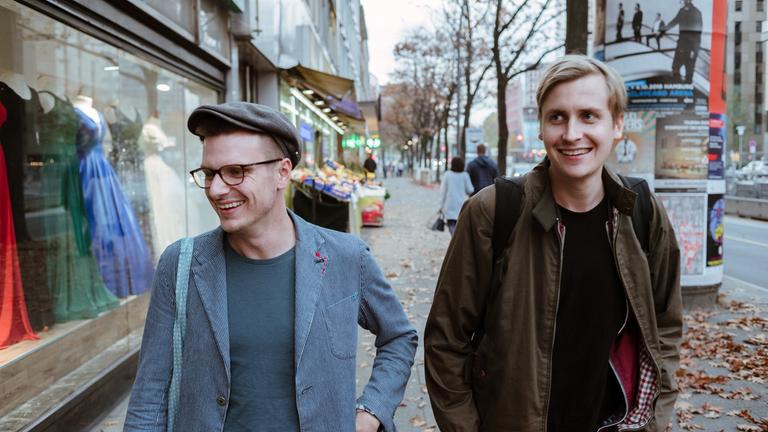 "Satire Battle": Till Reiners und Moritz Neumeier schlendern lachend an Schaufenstern vorbei.