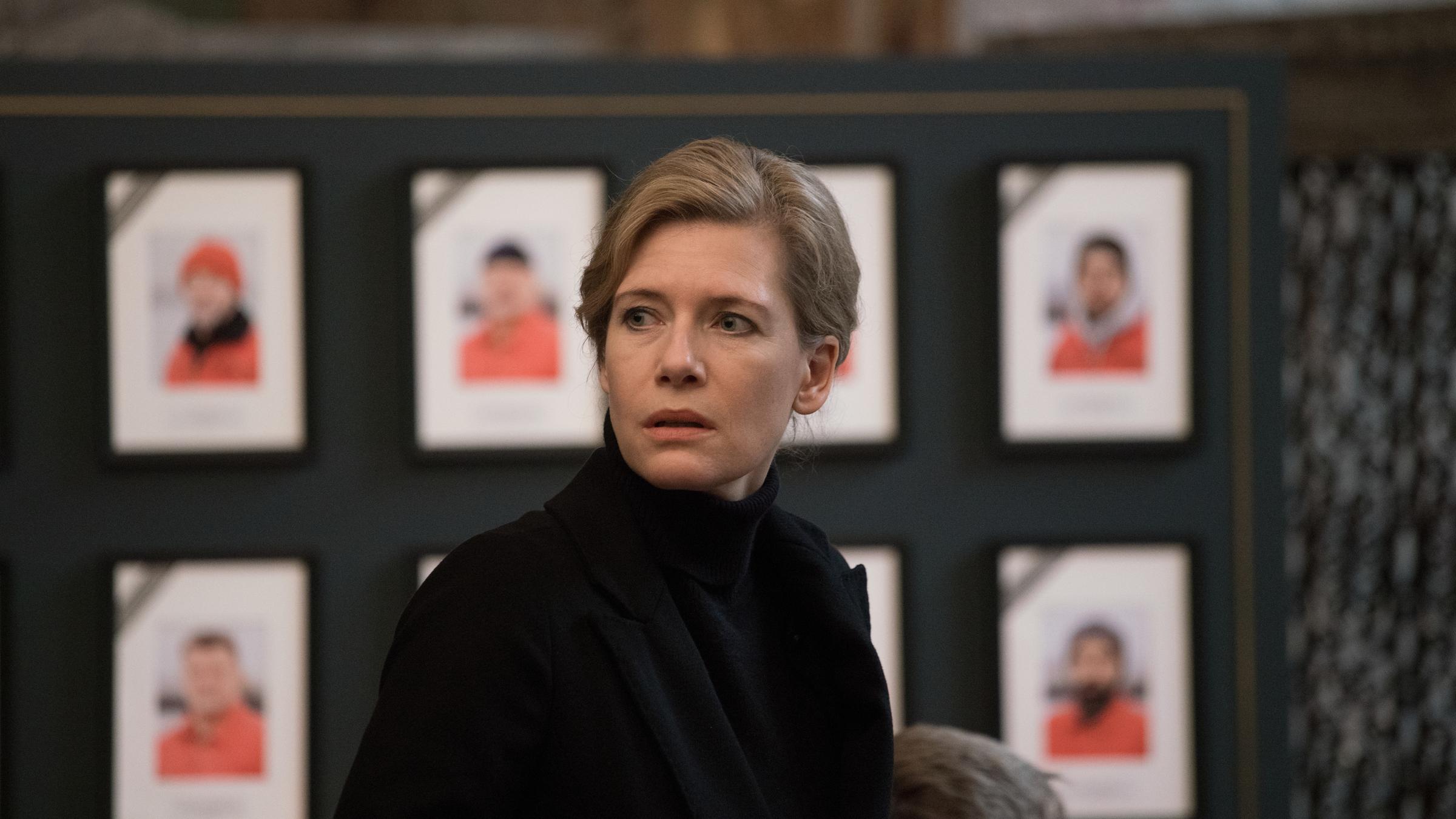 „Der Anfang von etwas": Anne (Ina Weisse) steht vor der Gedenktafel der Verstorbenen in Trauerkleidung.