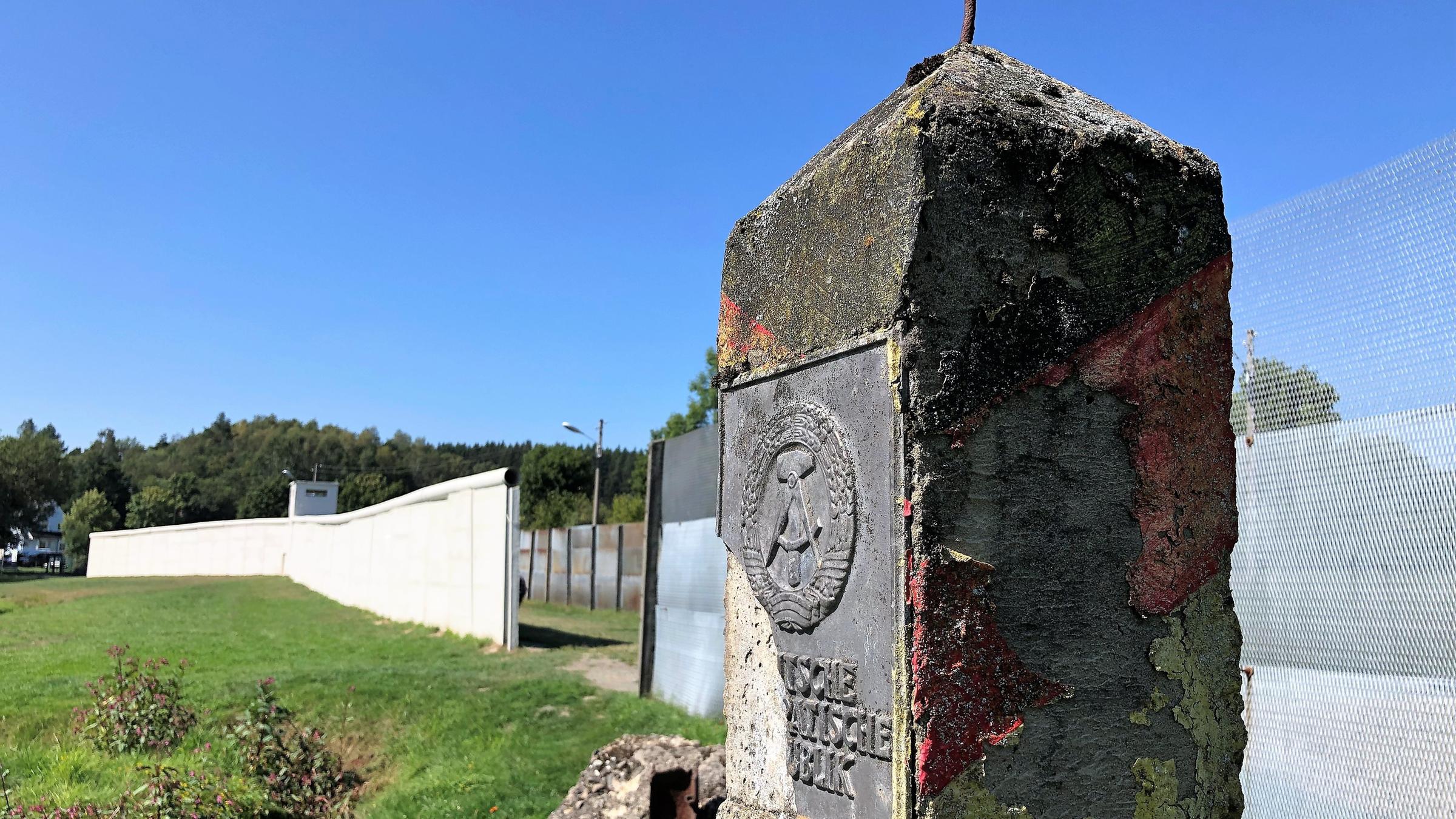 "Grenzgänger - Spurensuche am ehemaligen Todesstreifen": Ein alter Grenzstein der ehemaligen DDR steht entlang eines Zauns in einer Gedenkstätte.