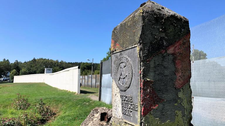 "Grenzgänger - Spurensuche am ehemaligen Todesstreifen": Ein alter Grenzstein der ehemaligen DDR steht entlang eines Zauns in einer Gedenkstätte.