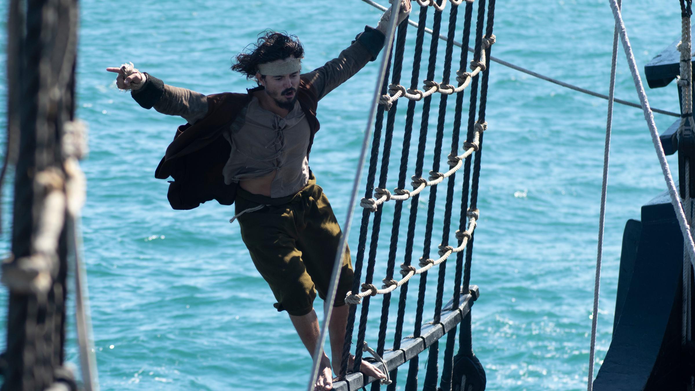 "Magellans Reise um die Erde - Das Abenteuer der ersten Weltumsegelung": Matrose (Juan Contreras Asencio) steht am Schiffsmast und breitet einen Arm aus.