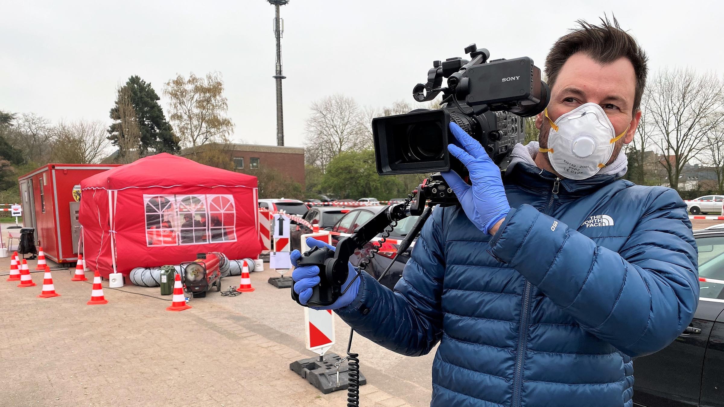 "ZDFzoom: Katastrophenschutz am Limit - Wie gut ist Deutschland aufgestellt?": Kameramann in blauer Jacke mit Atemschutzmaske.
