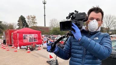 "ZDFzoom: Katastrophenschutz am Limit - Wie gut ist Deutschland aufgestellt?": Kameramann in blauer Jacke mit Atemschutzmaske.