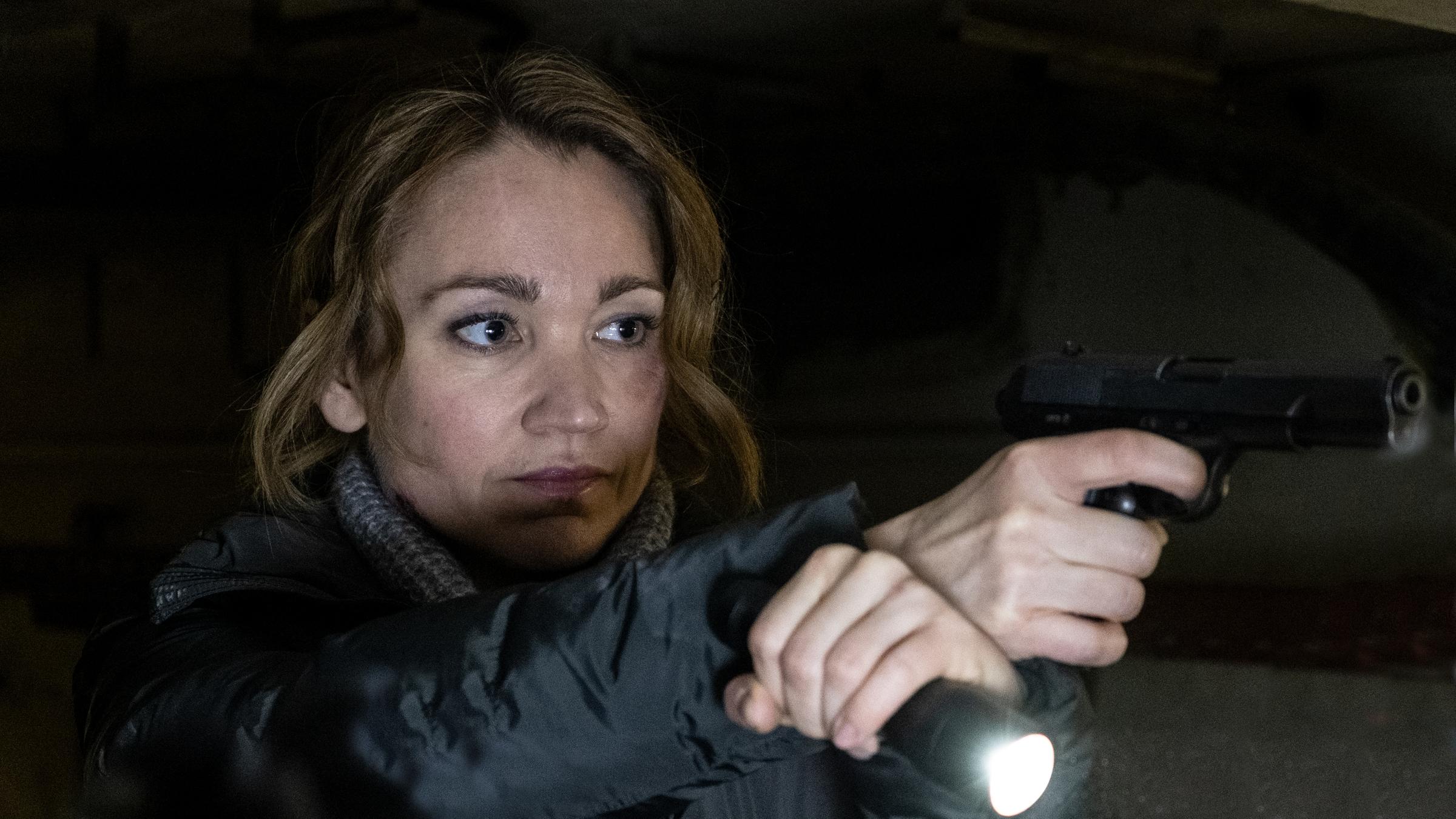 "Sarah Kohr - Teufelsmoor": Sarah Kohr (Lisa Maria Potthoff) hat in der einen Hand eine Taschenlampe und in der anderen Hand eine Waffe.