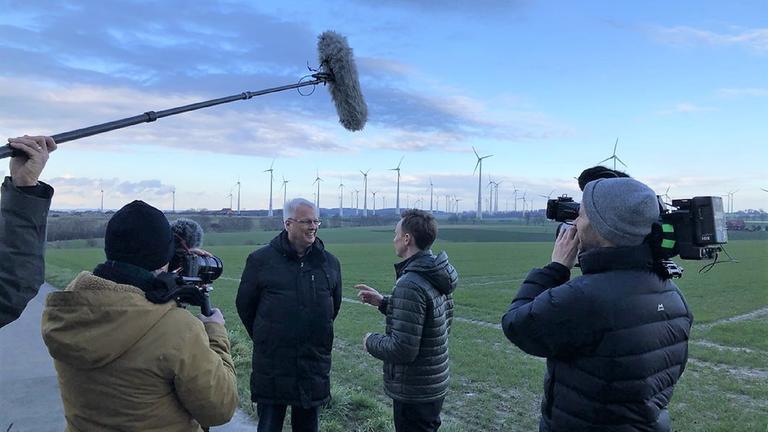 "ZDFzoom: Am Puls Deutschlands - Unterwegs mit Jochen Breyer": Jörg Dahm zeigt ZDF-Reporter Jochen Breyer die Windkraftwerke, die rund um sein Haus gebaut wurden.