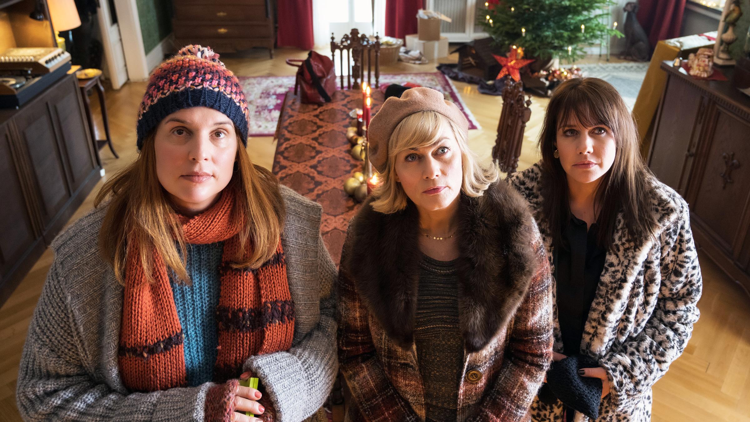 "Weihnachtstöchter": Katarina (Elena Uhlig), Regina (Gesine Cukrowski), Diana (Felicitas Woll) stehen im Wohnzimmer nebeneinander und schauen andächtig zum Portrait des gemeinsamen Vaters hoch.