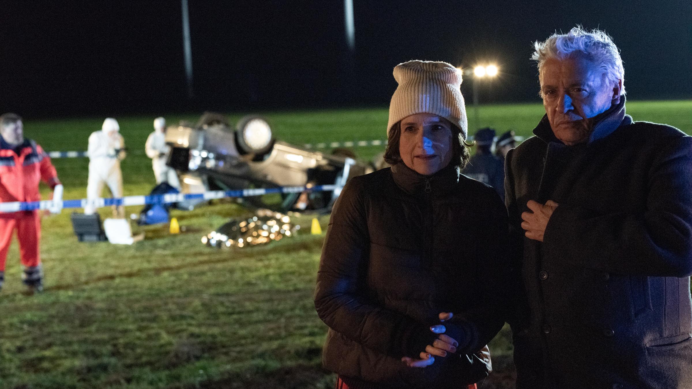 "Tage des letzten Schnees": Kommissarin Konstanze Satorius (Victoria von Trauttmansdorff) und ihr Kollege Johannes Fischer (Henry Hübchen) stehen in der kalten Nacht am Ort des Unfalls. Hinter ihnen liegt ein Auto auf dem Dach. Mitarbeiter der Spurensicherung sind bei Arbeit.