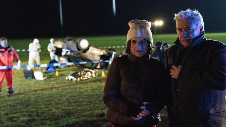 "Tage des letzten Schnees": Kommissarin Konstanze Satorius (Victoria von Trauttmansdorff) und ihr Kollege Johannes Fischer (Henry Hübchen) stehen in der kalten Nacht am Ort des Unfalls. Hinter ihnen liegt ein Auto auf dem Dach. Mitarbeiter der Spurensicherung sind bei Arbeit.