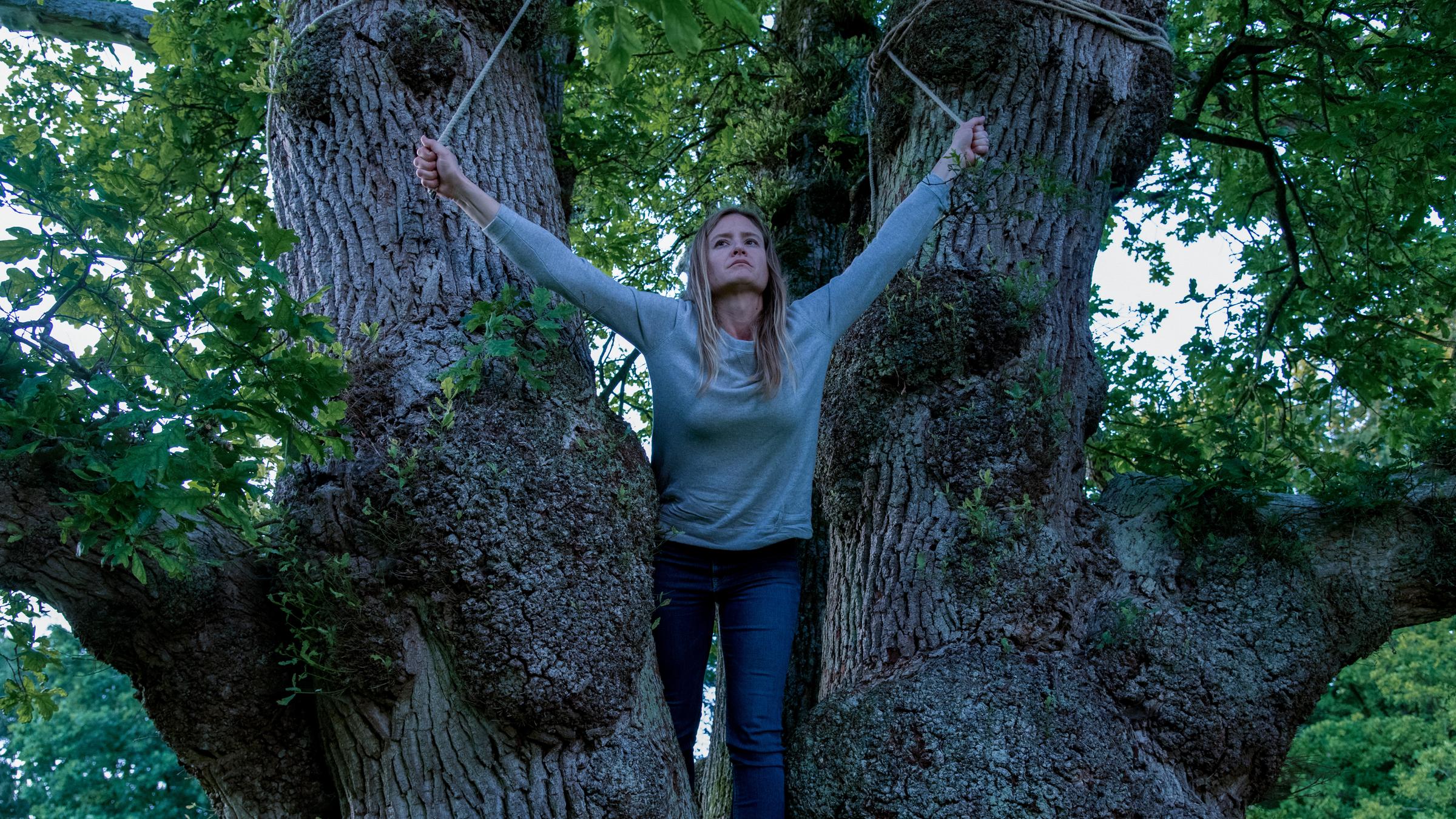  "Ostfriesengrab": Ann Kathrin Klaasen (Julia Jentsch) steht auf einem Baumstamm und hält sich an Seilen fest.