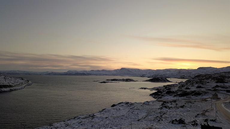 "Nordlichter - Leben am Polarkreis (1) - Von Spitzbergen bis Ostsibirien": Wasser, umgeben von schneebedeckter Fjörd-Landschaft bei Sonnenuntergang.