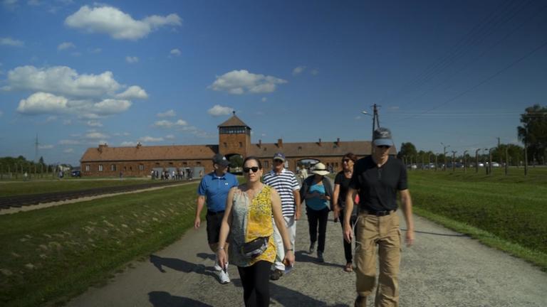 "Frontal 21-Dokumentation: Die letzten Zeugen von Auschwitz - Mahner der Zukunft": Die Amerikanerin Lori Gross Ripps mit weiteren Personen bei einem Besuch in Auschwitz.