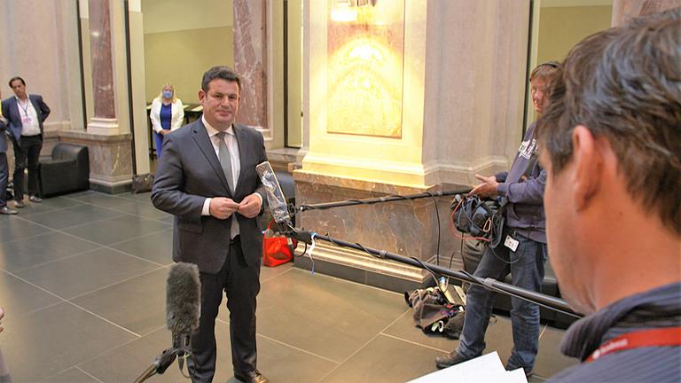 "ZDFzoom: Tönnies und die Werkverträge - Ausbeutung mitten in Deutschland": Hubertus Heil steht in der Lobby des Bundesrats, vor Kamerateams mit Mikrofonen.