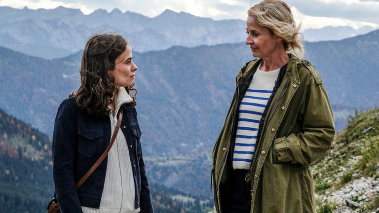 "Gipfelstürmer - Das Berginternat - Sehtest": Nele Seitz (Maya Haddad) und Bianca Racke (Franziska Schlattner) stehen sich vor grandioser Bergkulisse gegenüber und schauen sich an.