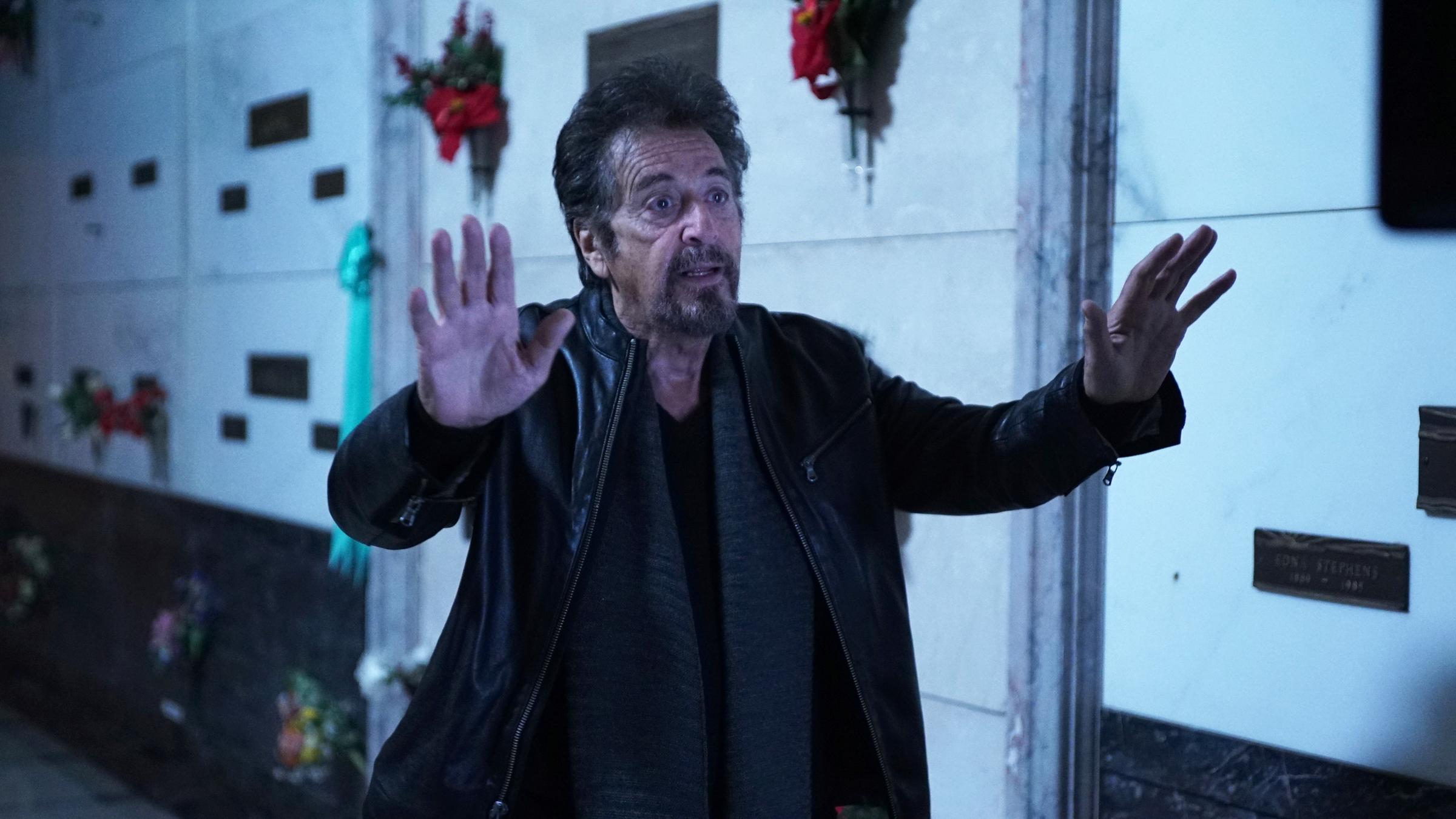 "Hangman - Spiel mit dem Tod": Archer (Al Pacino) steht mit erhobenen Händen in einer Trauerhalle in einem dunklen Gang voller Urnengräber.