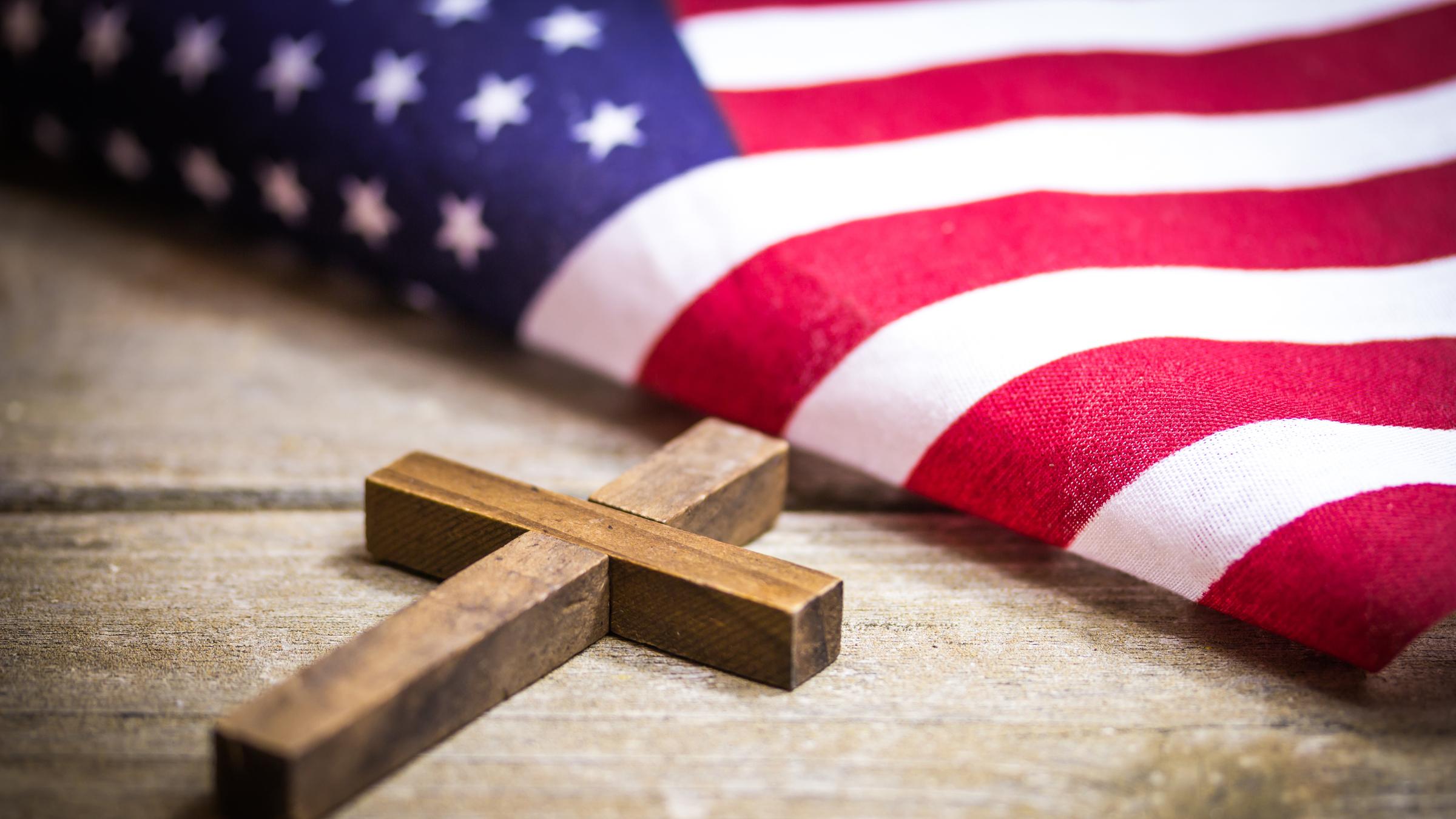 "Bibeltreue Supermacht - Evangelikale in den USA": Auf einem Tisch liegt ein Kreuz und die amerikanische Flagge.