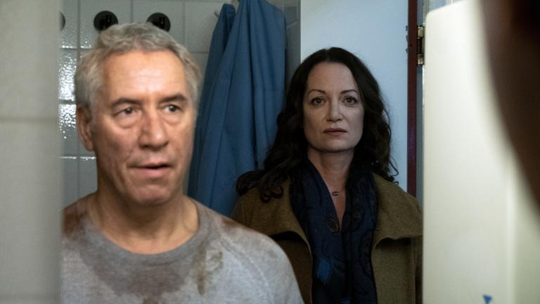 "Unter anderen Umständen - Über den Tod hinaus": Hamm (Ralph Herforth) und Jana (Natalia Wörner) stehen vor einem Spiegel hintereinander. Hamm trägt ein verdrecktes Sweatshirt.