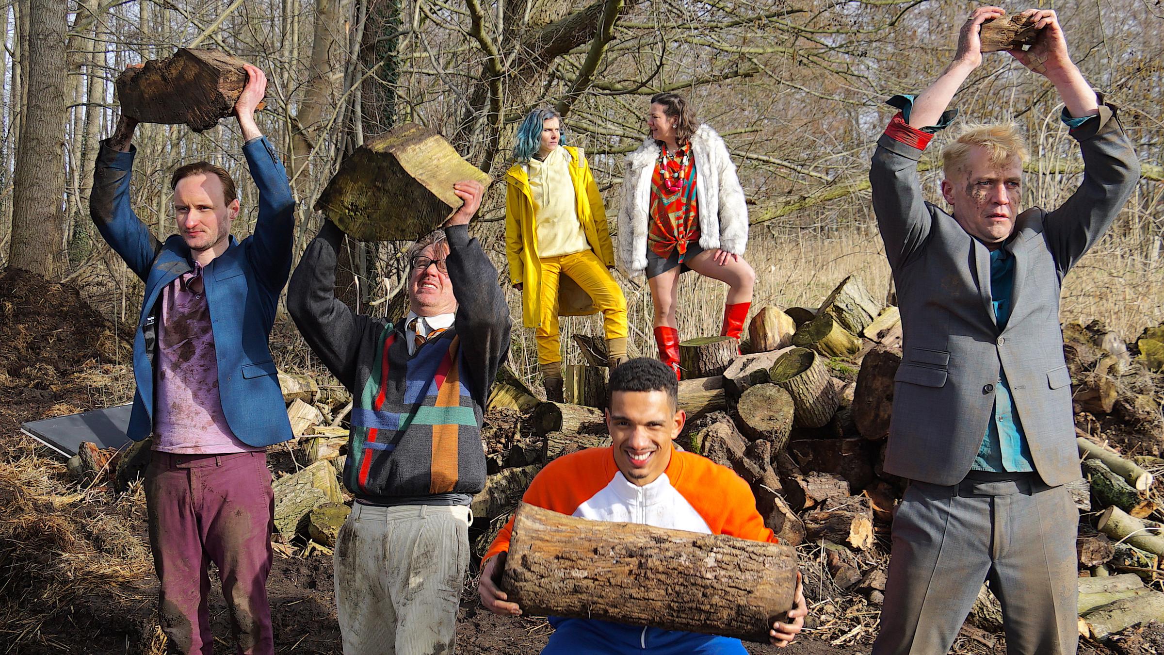 "#PRICKS": JULIAN (Sebastian Brandes), FERDINAND (Steffen C. Jürgens), KOBE (Karim Ben Mansur) und RALF (Nikolaus Kühn) stemmen im Wald Holz-Scheite als Gewichte, während LIN (Karin Hanczewski) und GLORIA (Bärbel Schwarz) sie überwachen.