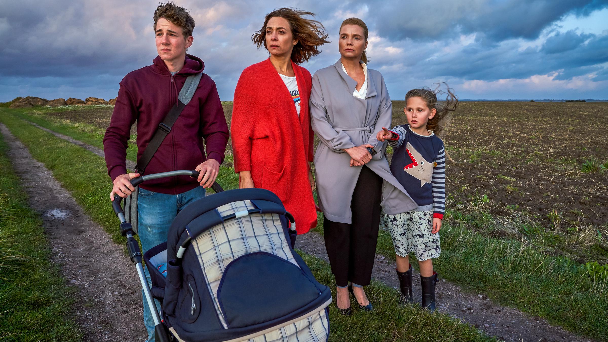 "Ella Schön - Feuertaufe": Draußen, auf einem Feldweg. Ella (Annette Frier), Christina (Julia Richter), Ben (Oscar Brose) und Klara (Zora Müller) stehen auf einem Feldweg und blicken in Schock in die Ferne.