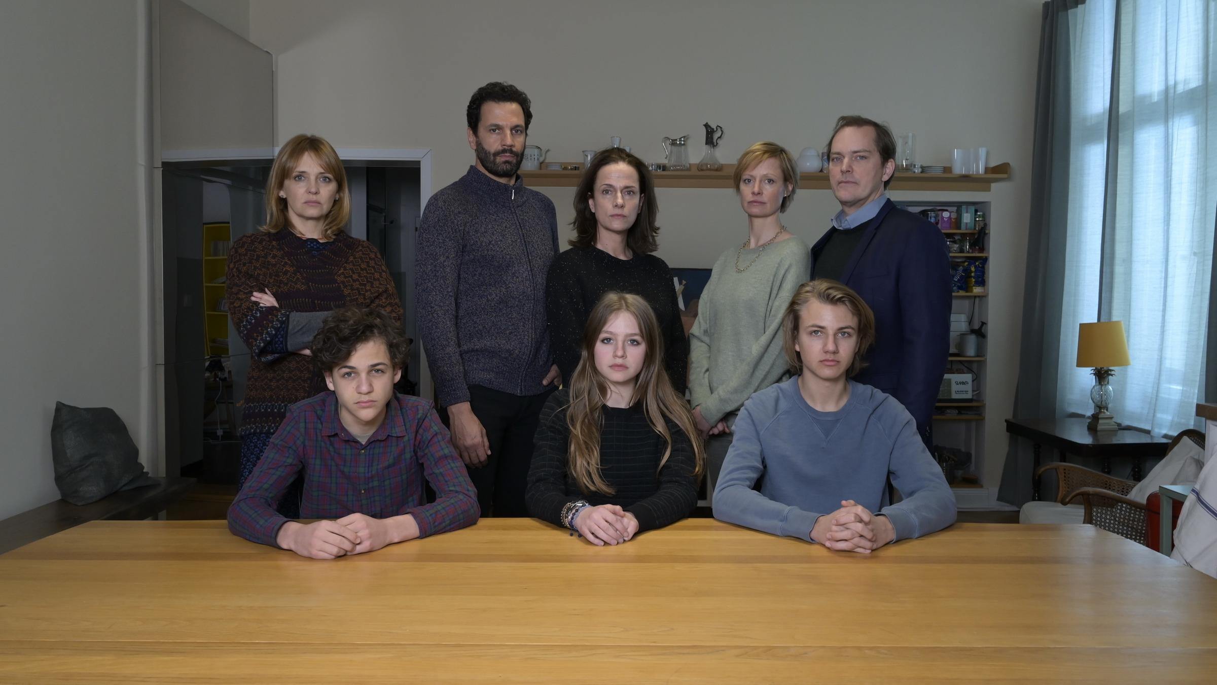 "Totgeschwiegen": Nele (Laura Tonke), Jean (Mehdi Nebbou), Esther (Claudia Michelsen), Brigitte (Katharina Marie Schubert), Volker (Godehard Giese), Jakob (Davis Ali Rashed), Mira (Flora Li Thiemann) und Fabian (Lenius Jung) haben sich in einem Wohnzimmer zu einem Gruppenbild zusammengefunden.