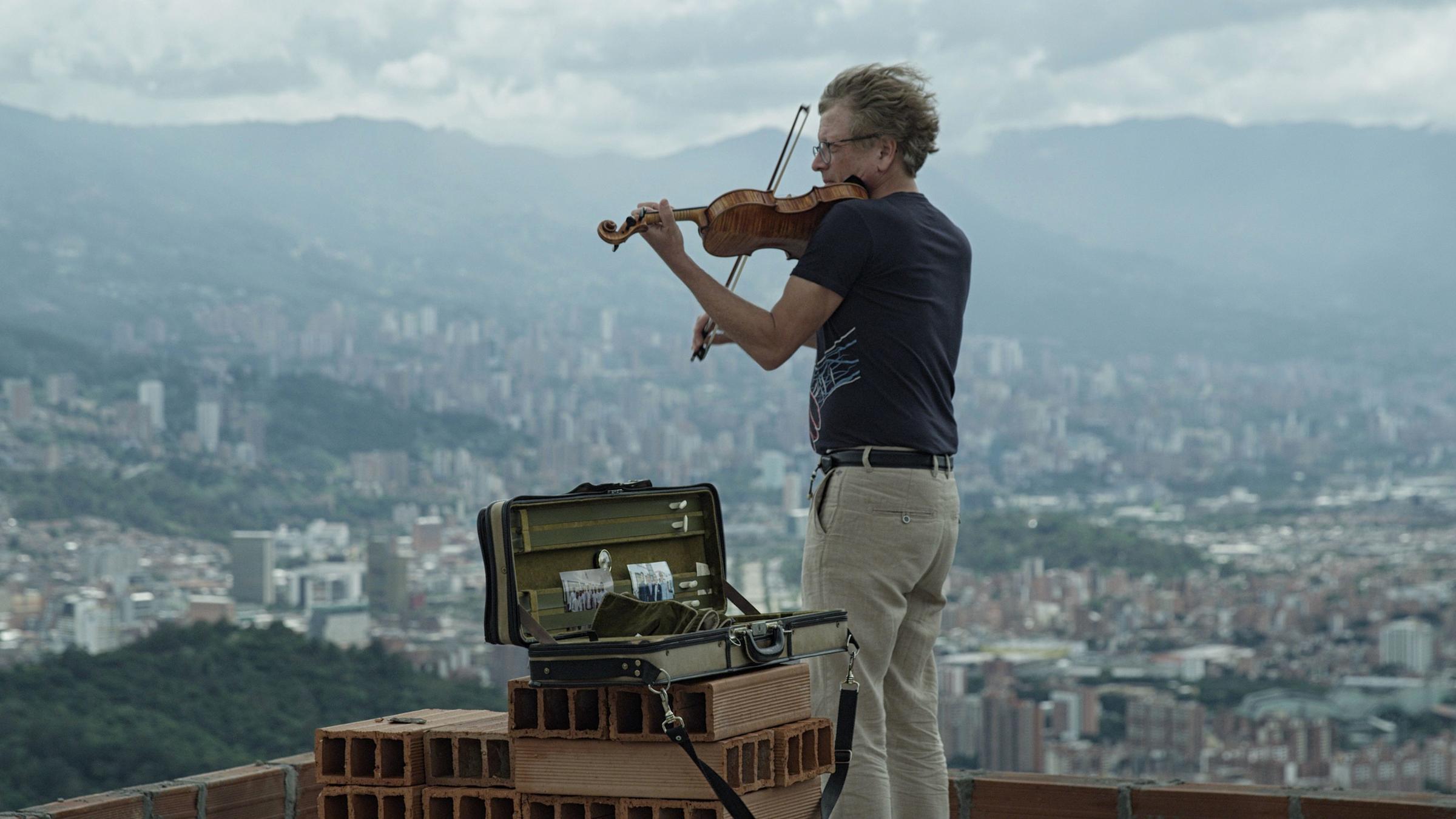 "'Diesen Kuss der ganzen Welt' – Beethoven heute": Ein Mann steht auf einem Dach über der kolumbianischen Stadt Medellín und spielt Geige.