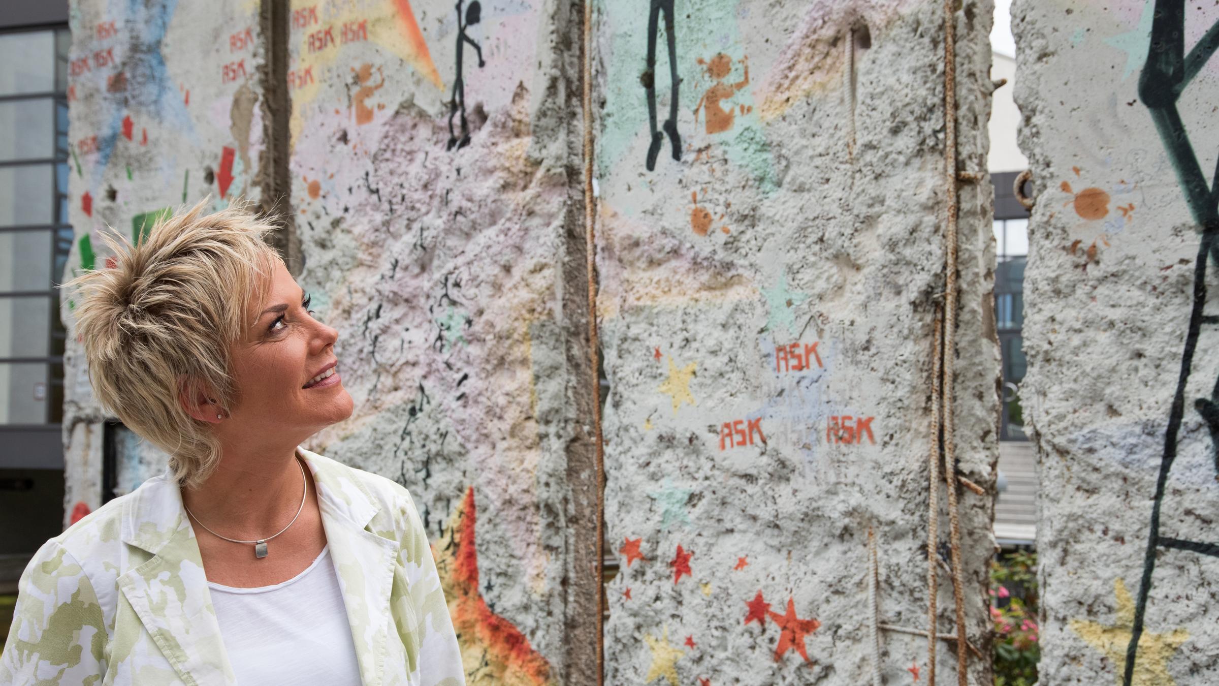 "ZDFzeit: Ein Staat geht - Abschied von der DDR": Inka Bause blickt auf ein Stück Berliner Mauer.