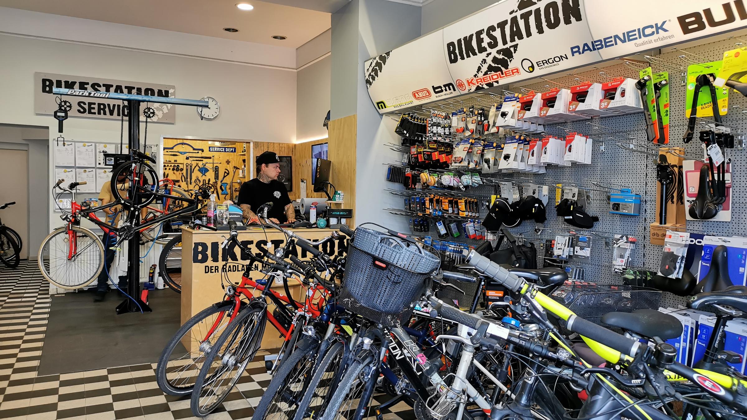  "ZDF.reportage: Die neue Lust am Radfahren": Im Innern eines Fahrradladens. Im Vordergrund stehen etliche Fahrräder, im Hintergrund arbeitet ein Mann am Tresen.