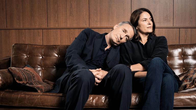 "Was uns nicht umbringt": Max (August Zirner) und Loretta (Barbara Auer) sitzen auf einer Couch eng nebeneinander. Er hat seinen Kopf auf ihre Schulter gelegt, Loretta greift nach seinem Arm.