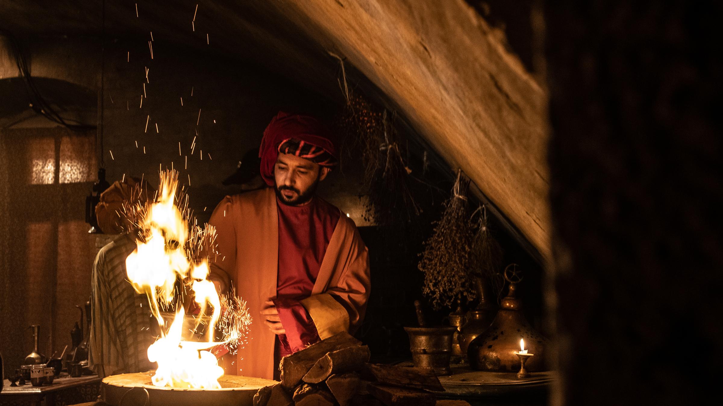 "Terra X: Kaffee - Geheimnisse eines Wundertranks": Spielszene: Ein Mann in traditioneller türkischer Kleidung steht an einer Feuerstelle.