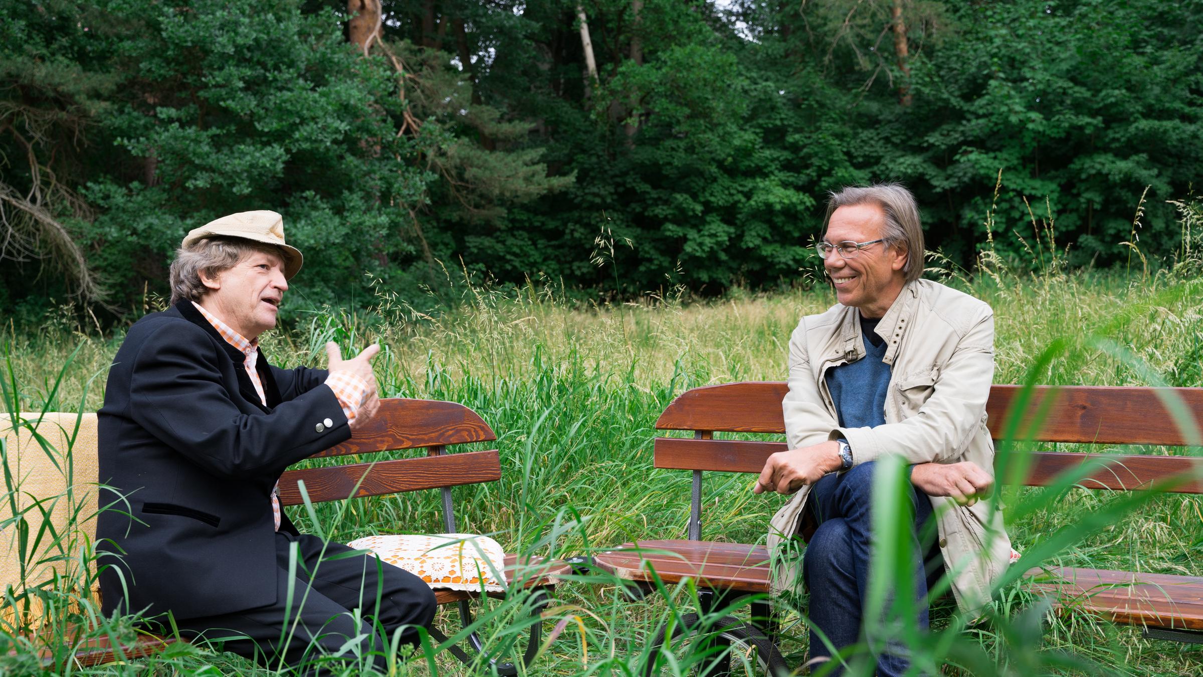 "Beim Pelzig auf der Bank - Scheiß Corona": Erwin Pelzig und Harald Welzer sitzen sich im Grünen auf Bänken gegenüber und diskutieren.